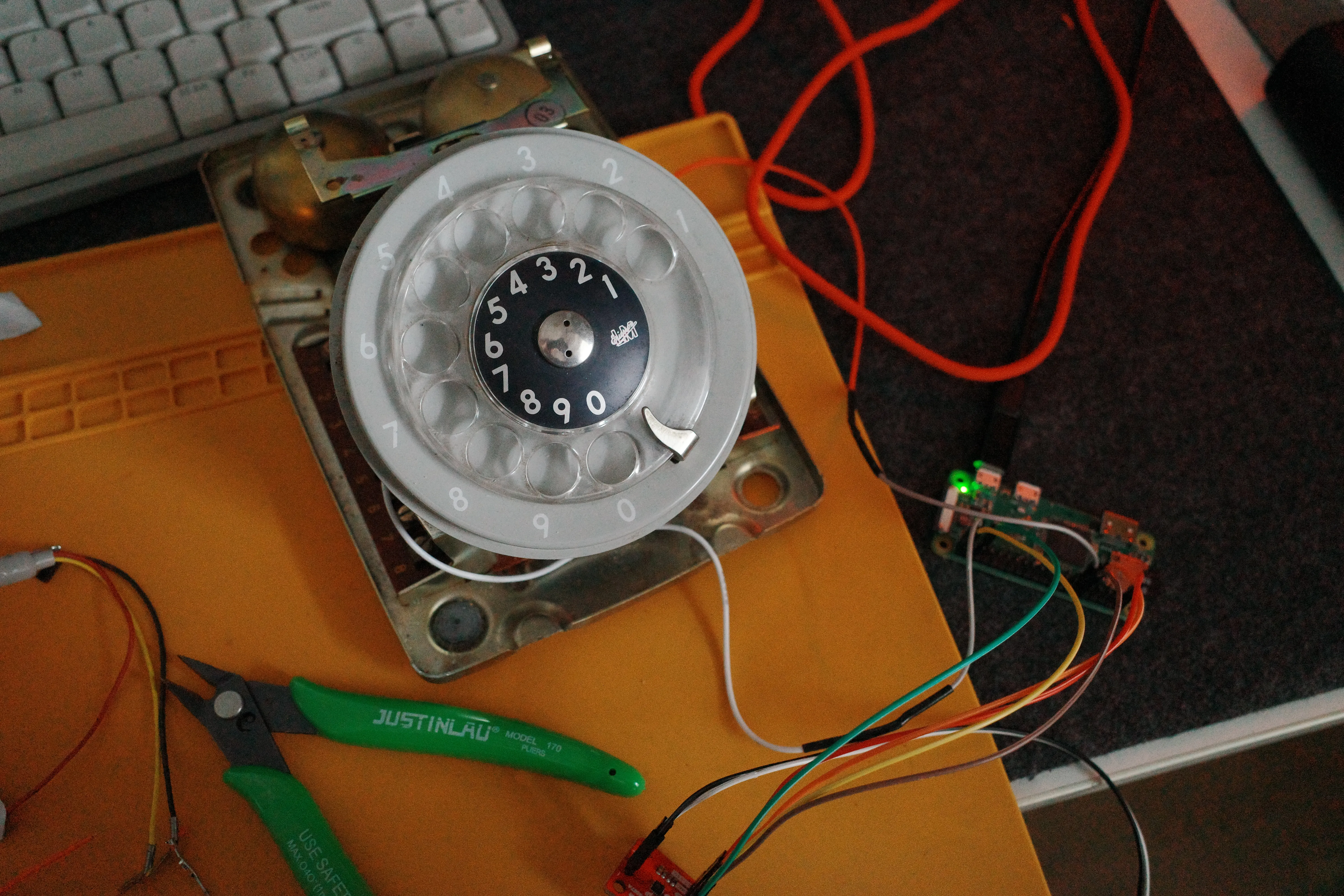 The opened rotary telephone beside the Raspberry Pi and test wiring
